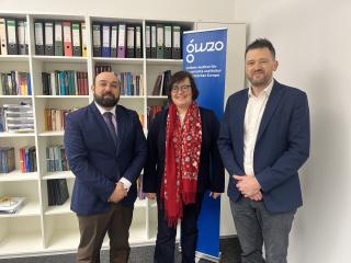 Drei Personen in formeller Kleidung stehen vor einem Bücherregal und einem blauen Banner mit der Aufschrift 'GWZO Leibniz-Institut für Geschichte und Kultur des östlichen Europas'