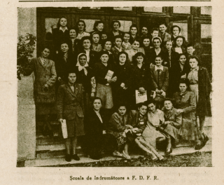Group of women posing on steps in front of a building.
