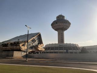 Kontrollturm und Terminalgebäude des Flughafens Zvartnots in Jerewan, mit markanter futuristischer Architektur und klar erkennbarem Betonbau.