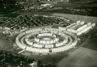 Luftaufnahme der Wohnsiedlung Rundling mit konzentrisch angeordneten, mehrstöckigen Wohngebäuden in kreisförmiger Anordnung und umliegenden rechteckigen Wohnblocks.