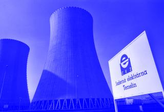 Zwei Kühltürme des Atomkraftwerks Temelín vor blauem Himmel, rechts ein Schild mit rotem CEZ-Logo und der Aufschrift »Jaderná elektrárna Temelín«.