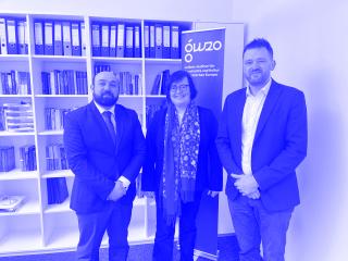 Drei Personen in formeller Kleidung stehen vor einem Bücherregal und einem blauen Banner mit der Aufschrift 'GWZO Leibniz-Institut für Geschichte und Kultur des östlichen Europas'