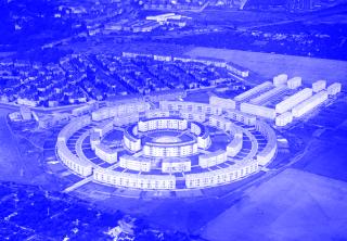 Luftaufnahme der Wohnsiedlung Rundling mit konzentrisch angeordneten, mehrstöckigen Wohngebäuden in kreisförmiger Anordnung und umliegenden rechteckigen Wohnblocks.