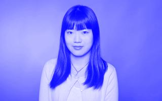 Schwarz-weiß Portrait, Frau mit langen, glatten Haaren vor einfarbigem Hintergrund.