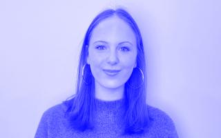 Portrait einer Person mit schulterlangen glatten Haaren und Kreolen in schwarz-weiß.