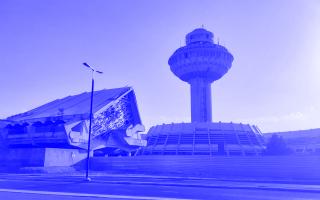 Kontrollturm und Terminalgebäude des Flughafens Zvartnots in Jerewan, mit markanter futuristischer Architektur und klar erkennbarem Betonbau.