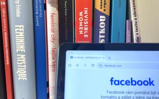 Bücherregal mit Büchern zu Feminismus und Frauenrechten, davor ein Bildschirm mit geöffneter Facebook-Webseite.