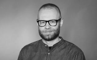 Schwarz-weiß-Porträt eines Mannes mit kurzem Haar und Brille