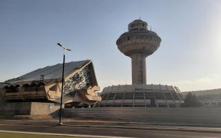 Kontrollturm und Terminalgebäude des Flughafens Zvartnots in Jerewan, mit markanter futuristischer Architektur und klar erkennbarem Betonbau.